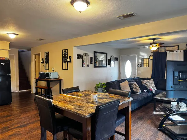 a living room with dining table and wooden floor