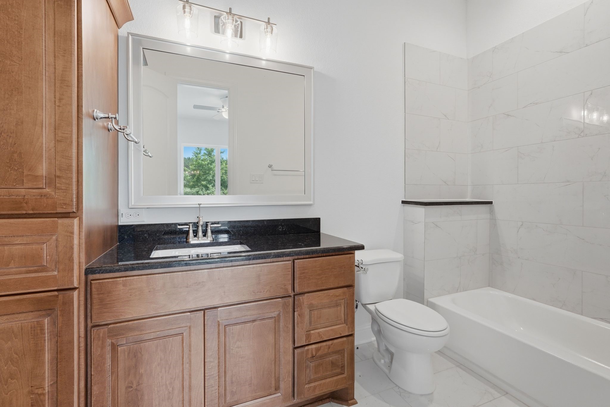 16081 Forest Mill Road Willis, TX 77378 - Photo 25 of 37 Beautifully finished secondary bathroom featuring rich wood cabinetry, granite countertops, and a tub/shower combination that blends style and functionality.