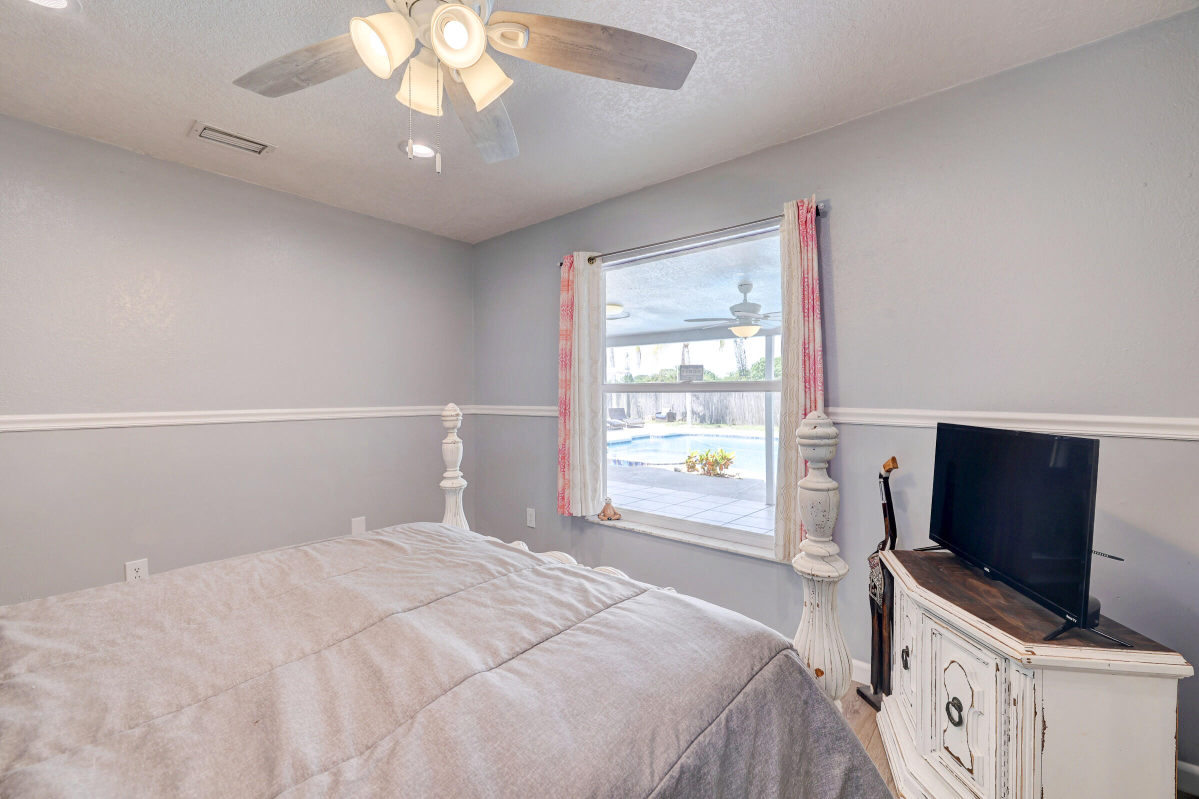 2068 Southeast Triumph Road Port St. Lucie, FL 34952 - Photo 15 of 59 a bedroom with a bed and a flat screen tv