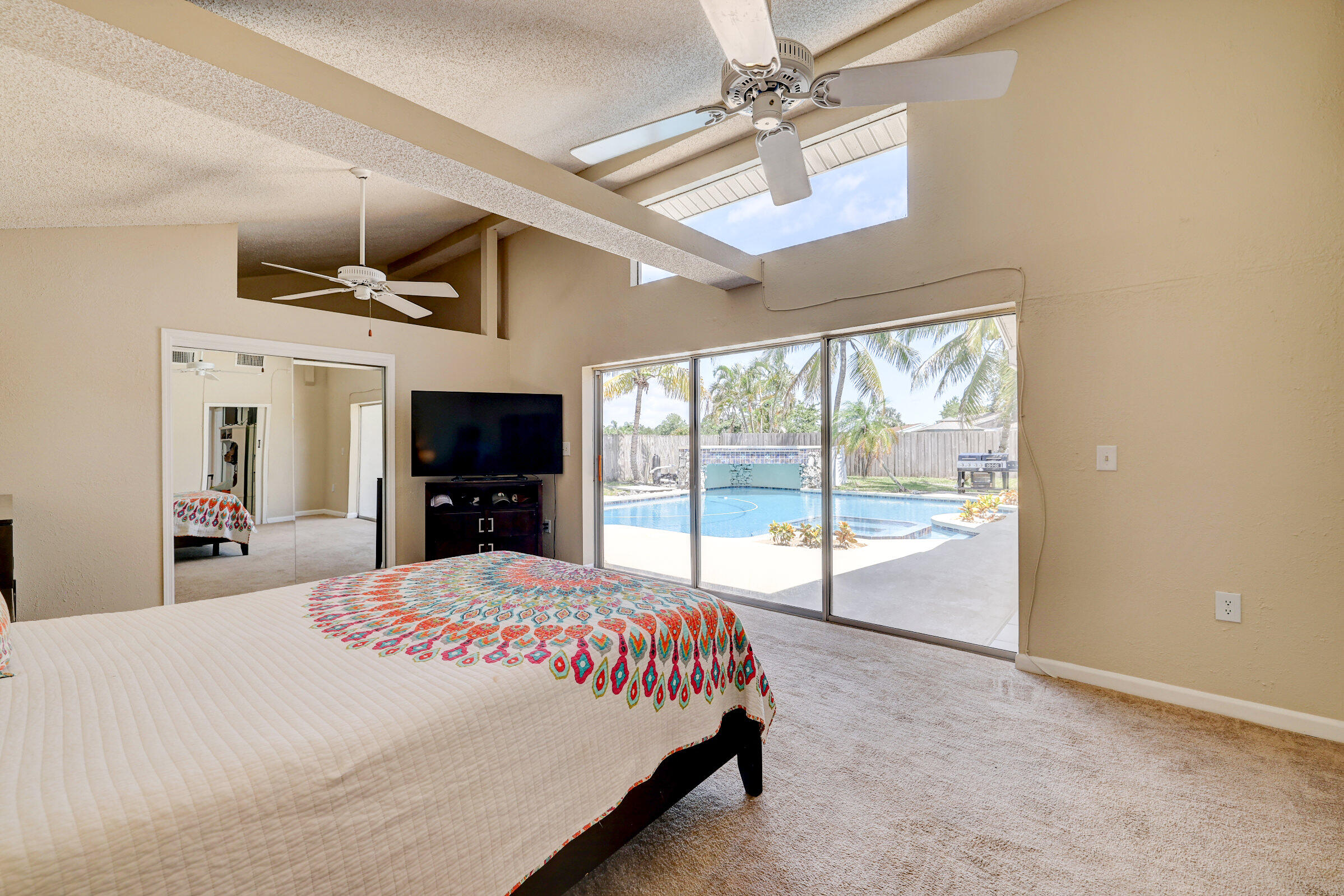 2068 Southeast Triumph Road Port St. Lucie, FL 34952 - Photo 22 of 59 a large bedroom with a bed and a flat screen tv