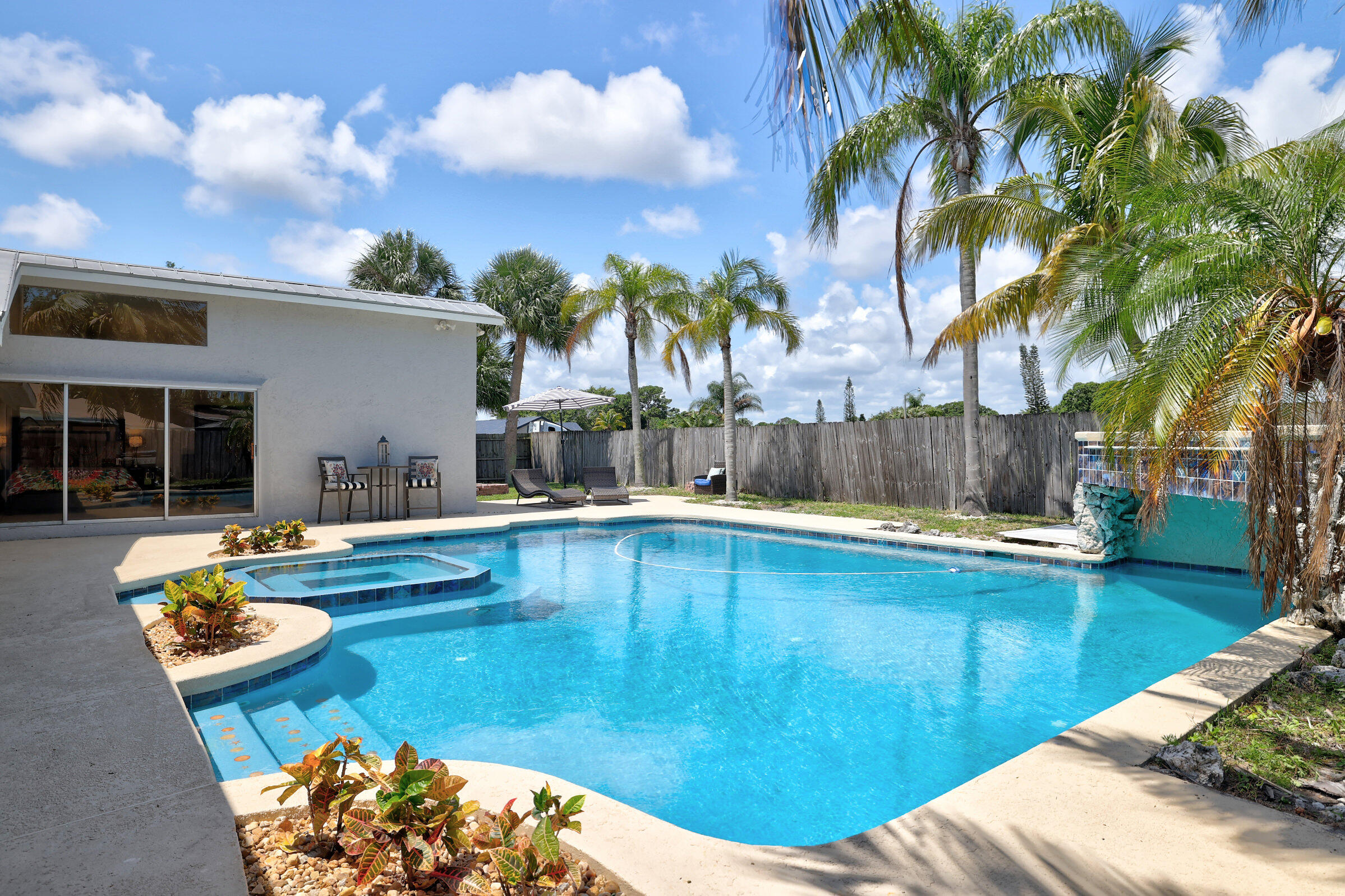 2068 Southeast Triumph Road Port St. Lucie, FL 34952 - Photo 36 of 59 a view of a swimming pool with a lounge chairs