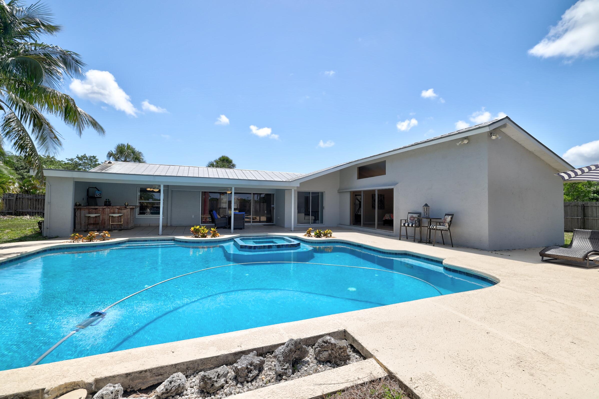 2068 Southeast Triumph Road Port St. Lucie, FL 34952 - Photo 42 of 59 a view of a house with swimming pool and furniture