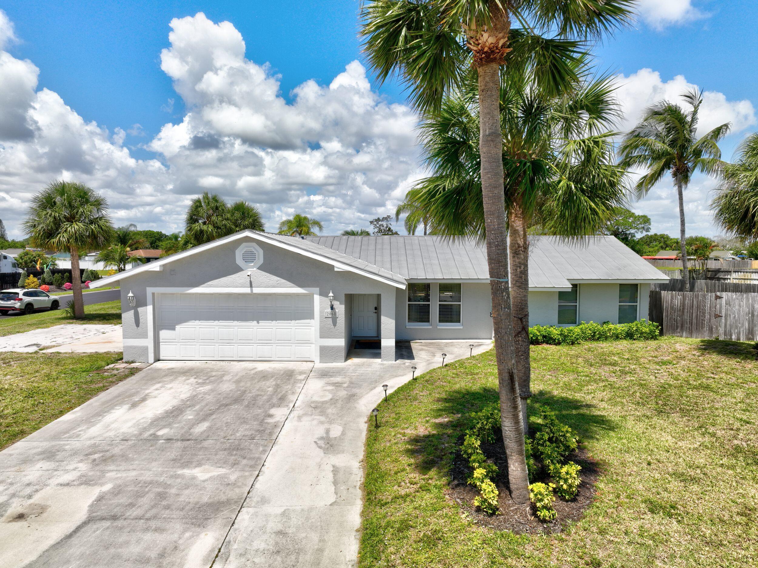 2068 Southeast Triumph Road Port St. Lucie, FL 34952 - Photo 44 of 59 a front view of a house with garden