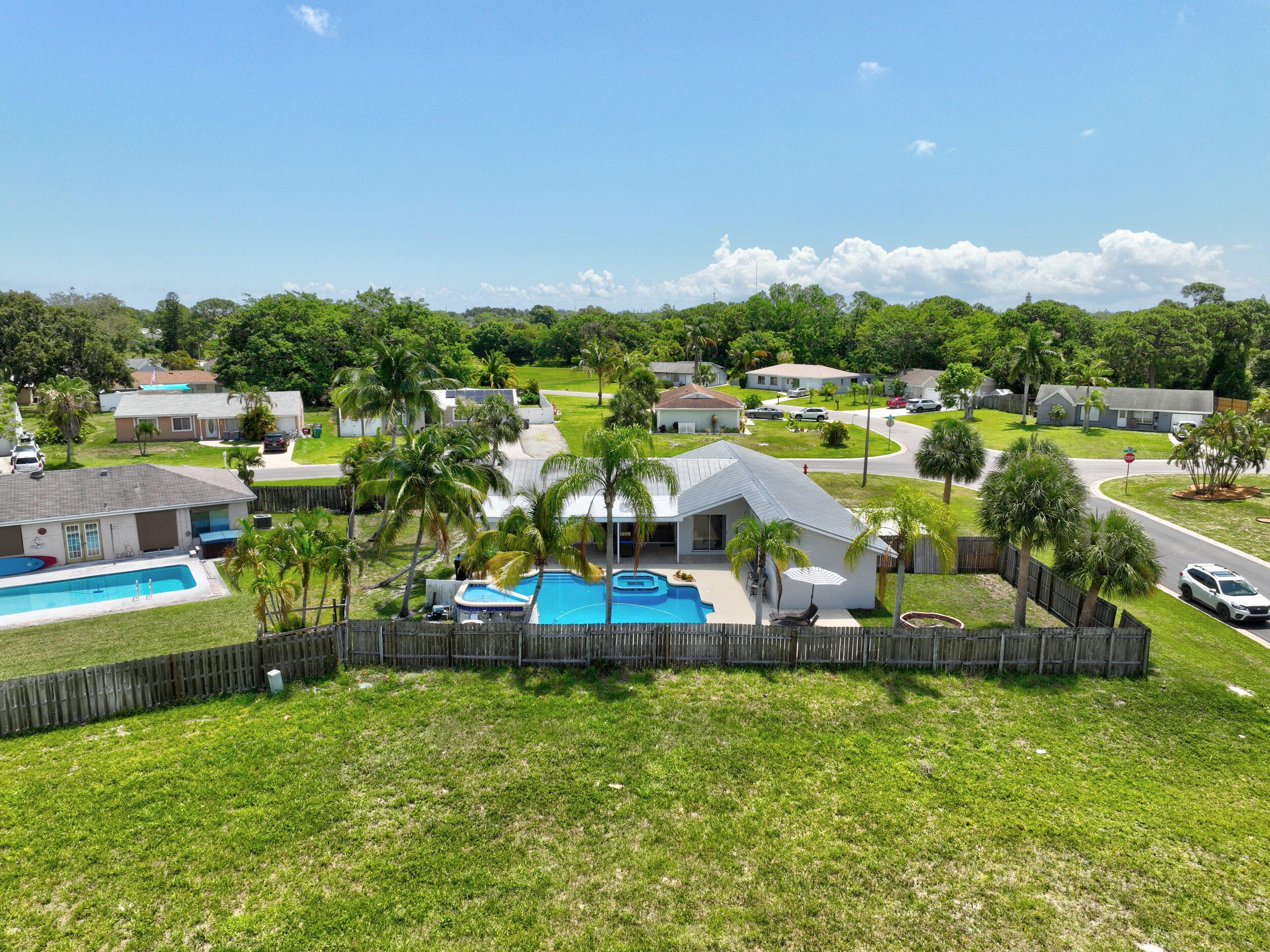 2068 Southeast Triumph Road Port St. Lucie, FL 34952 - Photo 54 of 59 a view of a house with a big yard and large trees