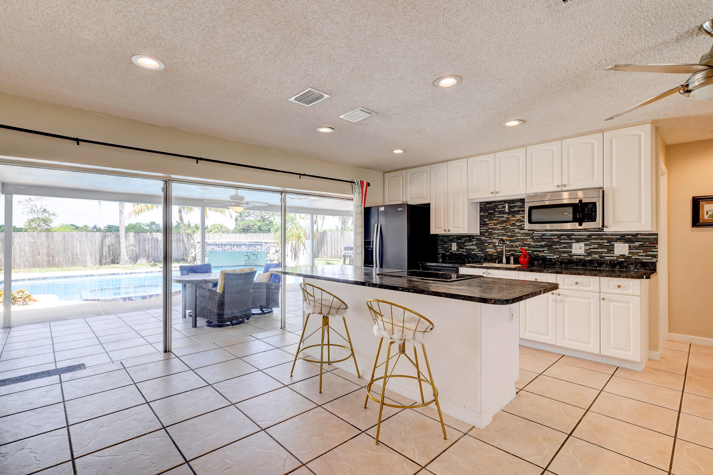 2068 Southeast Triumph Road Port St. Lucie, FL 34952 - Photo 7 of 59 a kitchen with stainless steel appliances granite countertop a stove a sink a microwave and a refrigerator