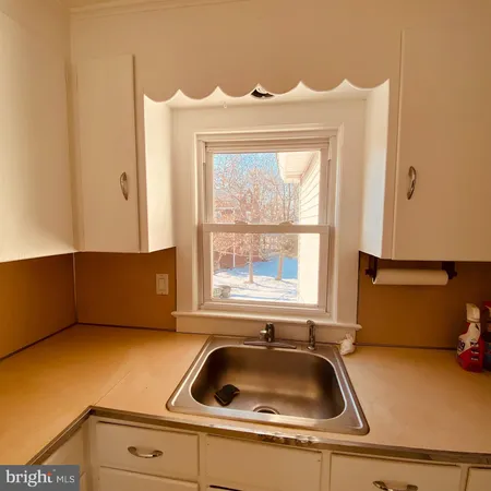 a kitchen with a sink cabinets and a window