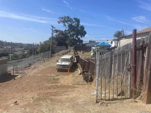 a view of a backyard with wooden fence