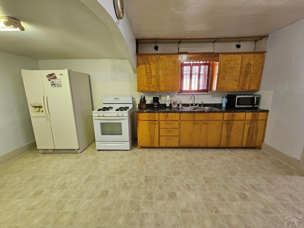 1049 Tipton Street Springfield, CO 81073 - Photo 7 of 20 a view of a kitchen with a sink dishwasher a refrigerator and a stove