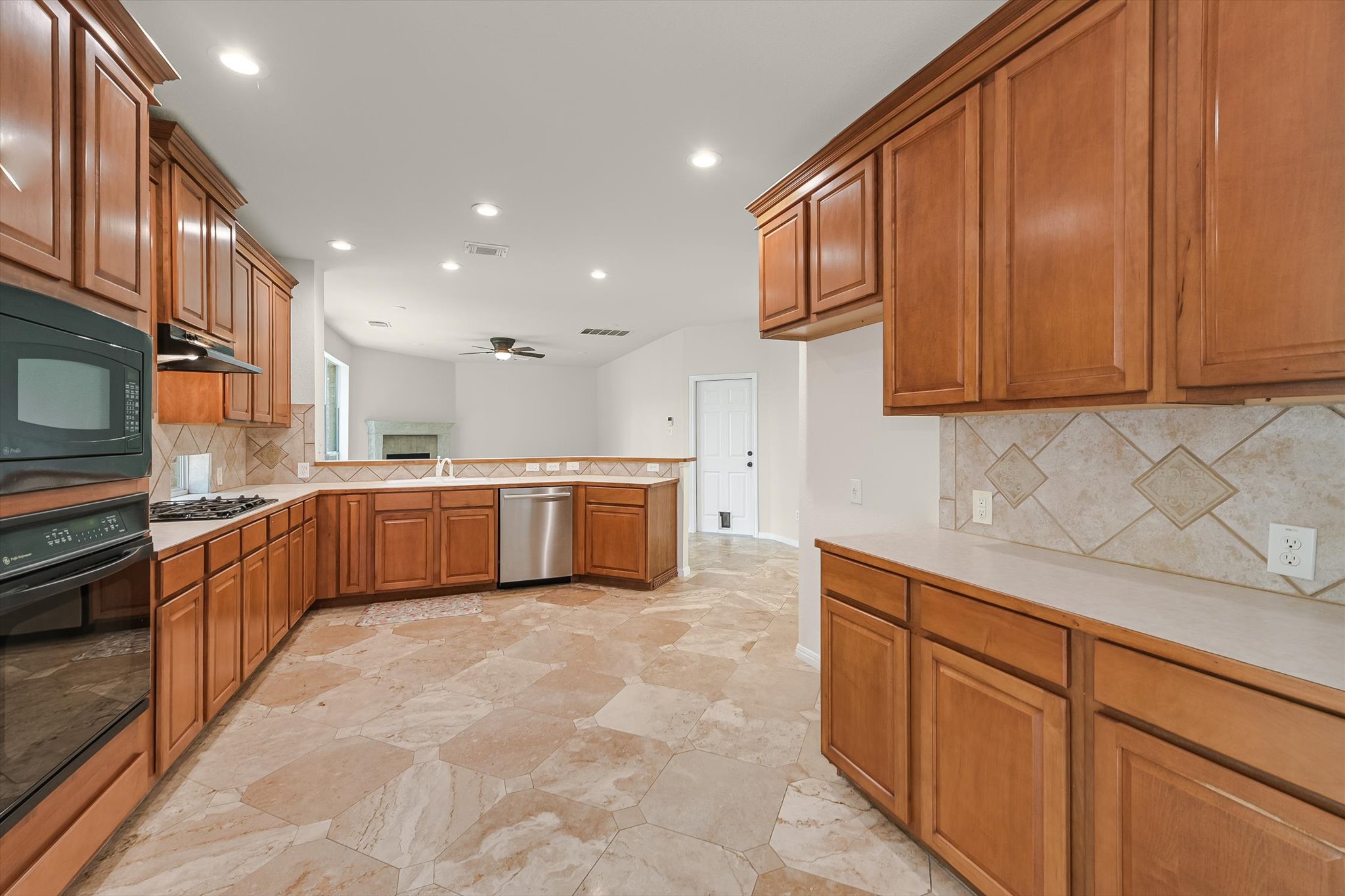 2849 Grimes Ranch Road Austin, TX 78732 - Photo 10 of 31 A well-appointed culinary space featuring ample cabinetry and patterned tile flooring, connecting to an airy living area.