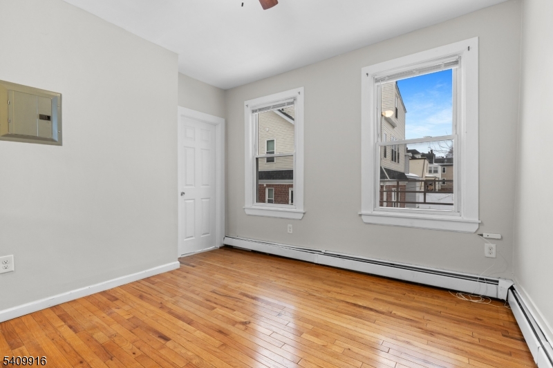 336 Madison Avenue, Unit 2 Newark, NJ 07108 - Photo 3 of 11 a view of an empty room with wooden floor and a window