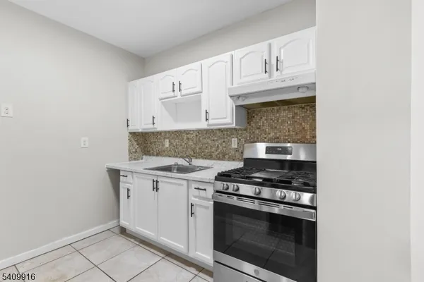 a kitchen with white cabinets and appliances