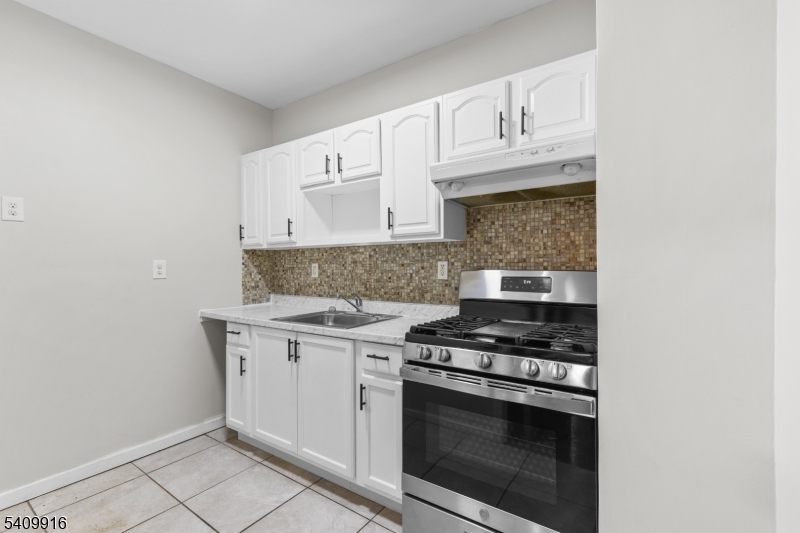 336 Madison Avenue, Unit 2 Newark, NJ 07108 - Photo 4 of 11 a kitchen with white cabinets and appliances