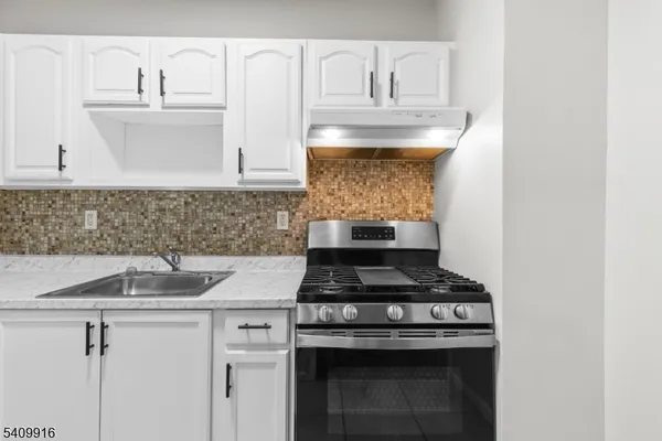 a kitchen with white cabinets and appliances