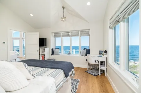 a bedroom with a bed and large windows