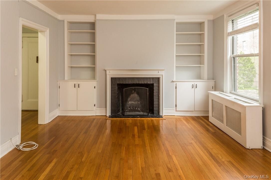 64 Sagamore Road, Unit H3 Bronxville, NY 10708 - Photo 3 of 12 Living Room featuring fireplace, built-in shelving and hardwood floors.