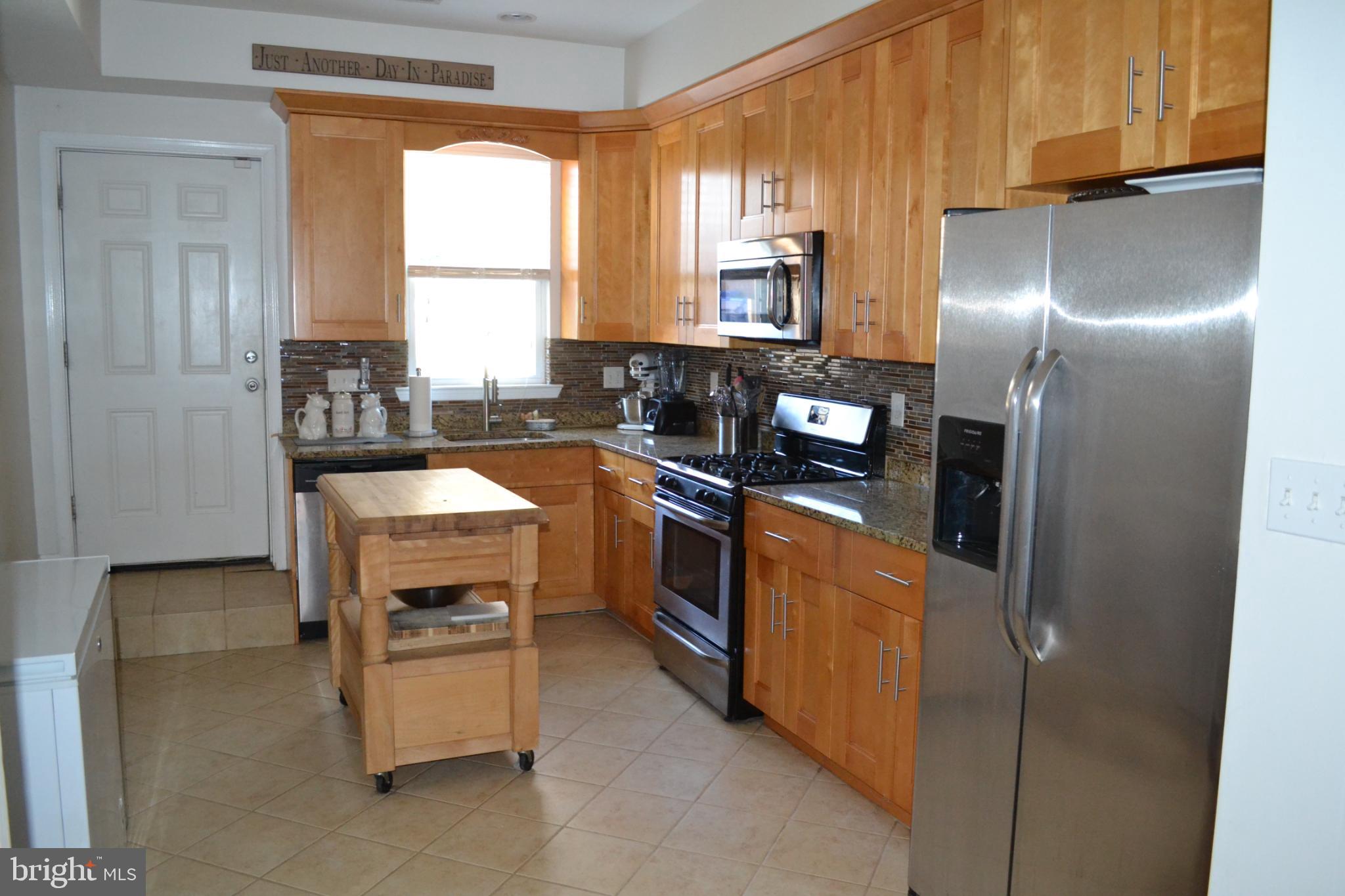 1410 North Bond Street Baltimore, MD 21213 - Photo 7 of 26 a kitchen with stainless steel appliances granite countertop a stove a sink and a refrigerator