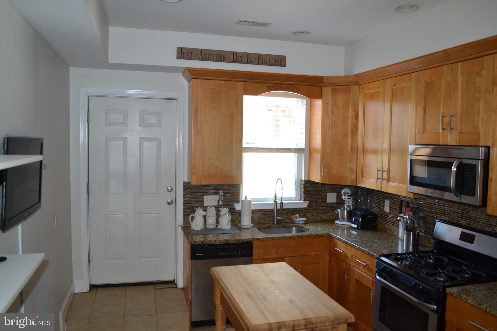 1410 North Bond Street Baltimore, MD 21213 - Photo 8 of 26 a kitchen with stainless steel appliances granite countertop a stove a sink and a microwave