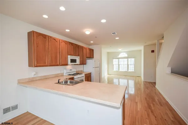 a room with stainless steel appliances a sink dishwasher stove and wooden floor