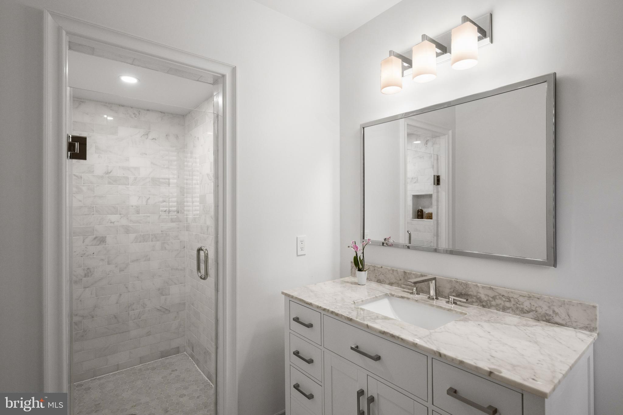 2931 Foxhall Road Northwest Washington, DC 20016 - Photo 35 of 62 a bathroom with a granite countertop sink and a mirror