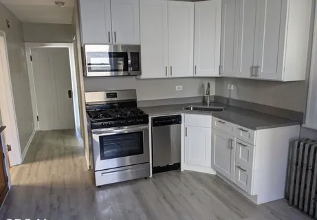 a kitchen with granite countertop white cabinets and appliances