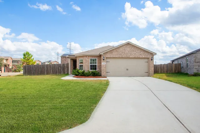 a front view of a house with a garden and yard