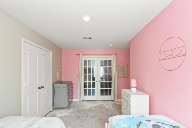 a spacious bedroom with a bed and wooden floor