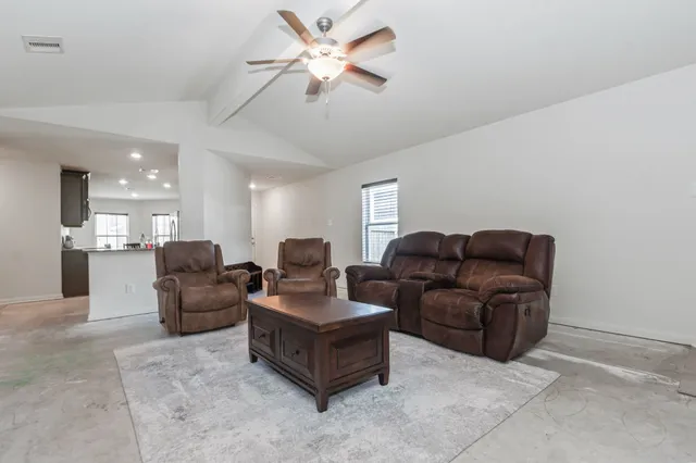 a living room with couches and kitchen view
