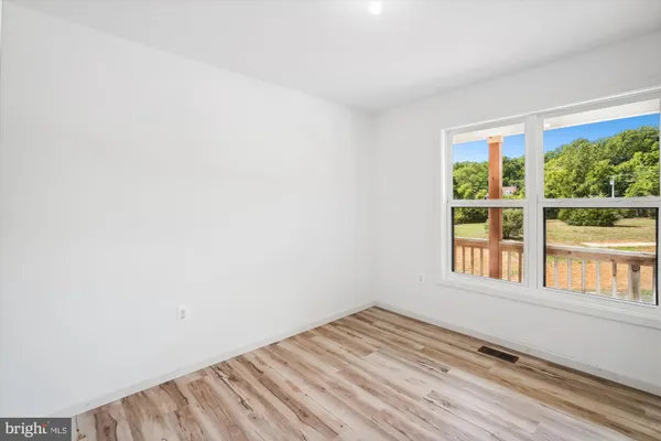 an empty room with a window and a fan