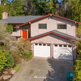 a front view of a house with a yard and trees