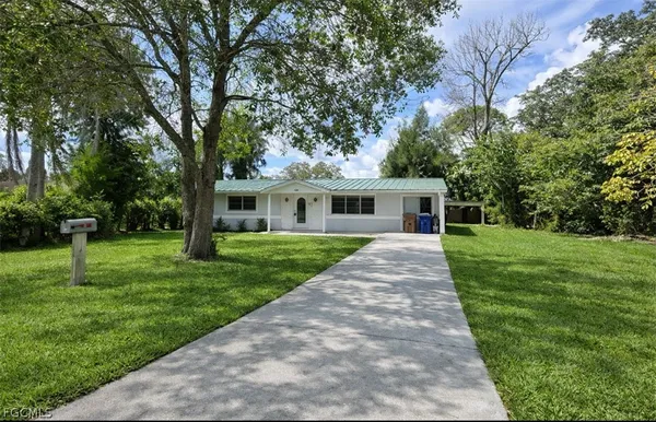 a front view of a house with a yard and tree
