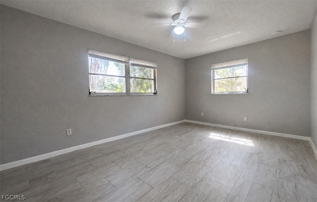 424 Cactus Circle Lehigh Acres, FL 33936 - Photo 12 of 18 wooden floor in an empty room with a window
