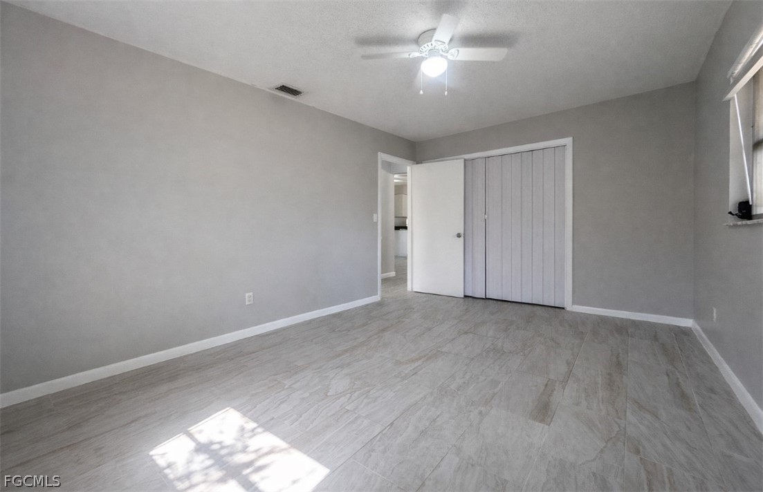 424 Cactus Circle Lehigh Acres, FL 33936 - Photo 13 of 18 a view of empty room with wooden floor and fan