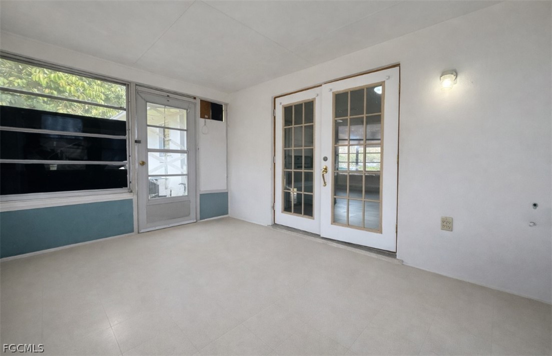 424 Cactus Circle Lehigh Acres, FL 33936 - Photo 17 of 18 a view of an empty room with a window and wooden floor