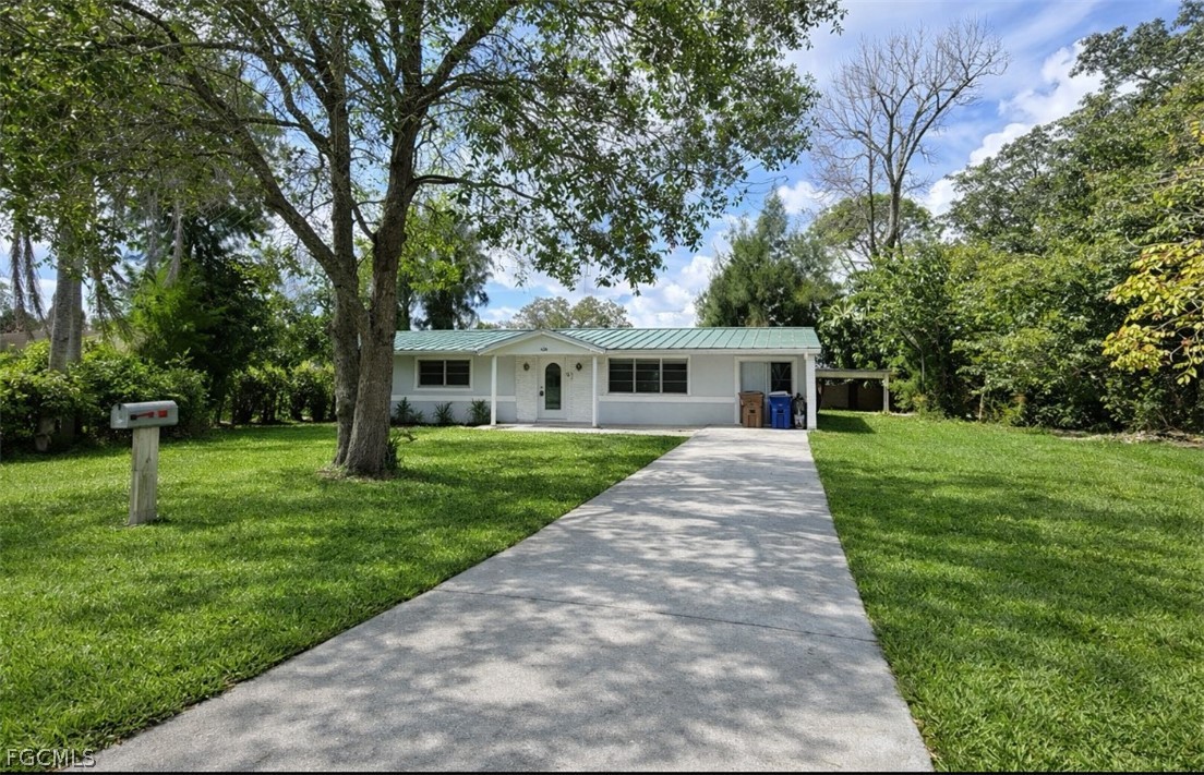424 Cactus Circle Lehigh Acres, FL 33936 - Photo 2 of 18 a front view of a house with a yard and tree