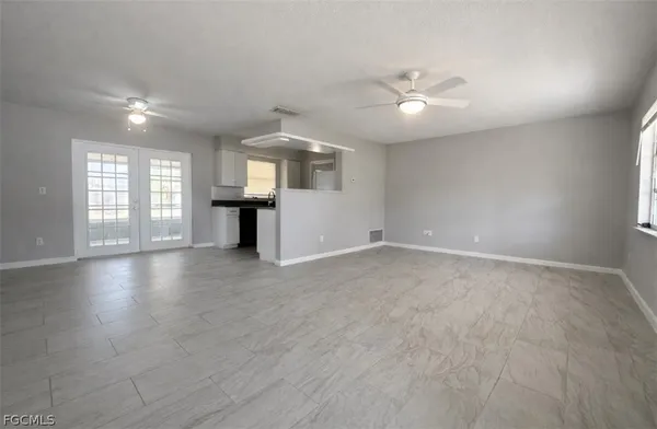 an empty room with windows and cabinet