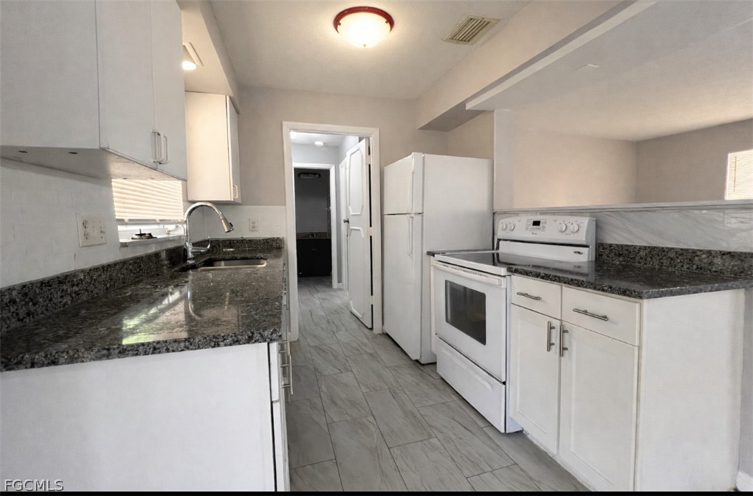 424 Cactus Circle Lehigh Acres, FL 33936 - Photo 4 of 18 a kitchen with stainless steel appliances granite countertop a sink stove and refrigerator