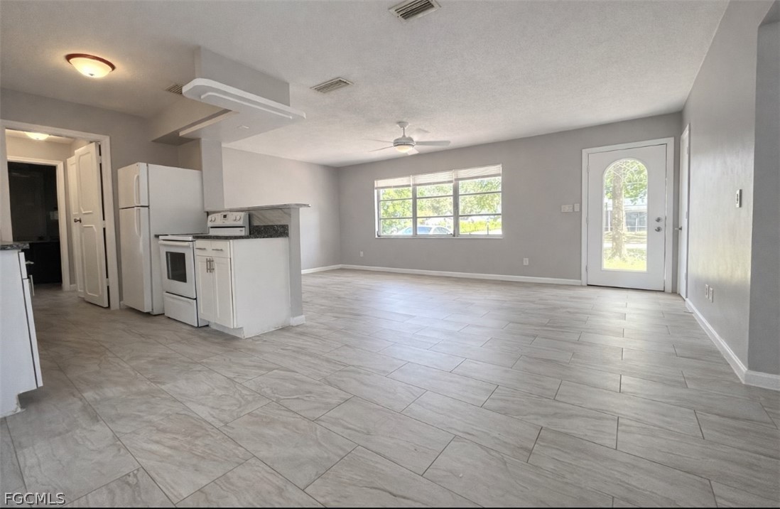 424 Cactus Circle Lehigh Acres, FL 33936 - Photo 6 of 18 an empty room with windows and kitchen view
