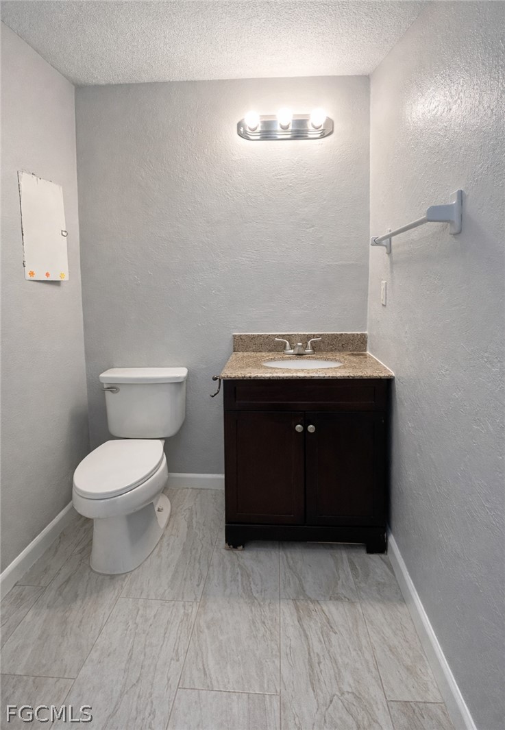 424 Cactus Circle Lehigh Acres, FL 33936 - Photo 8 of 18 a bathroom with a toilet and a sink