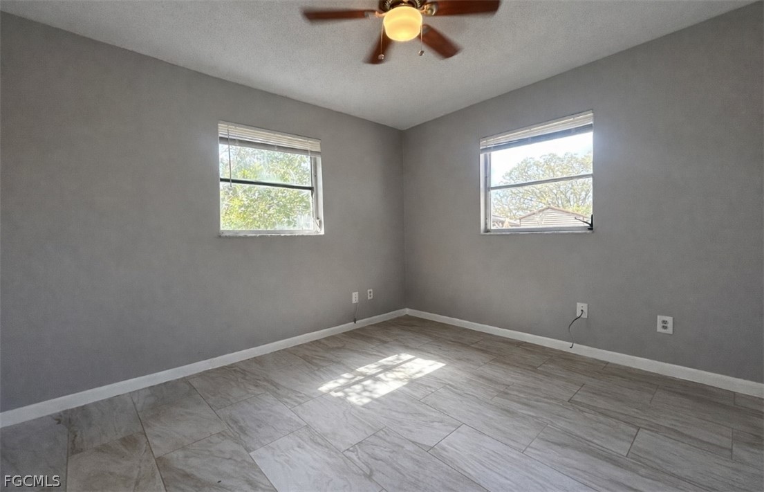 424 Cactus Circle Lehigh Acres, FL 33936 - Photo 10 of 18 a view of empty room with wooden floor and fan