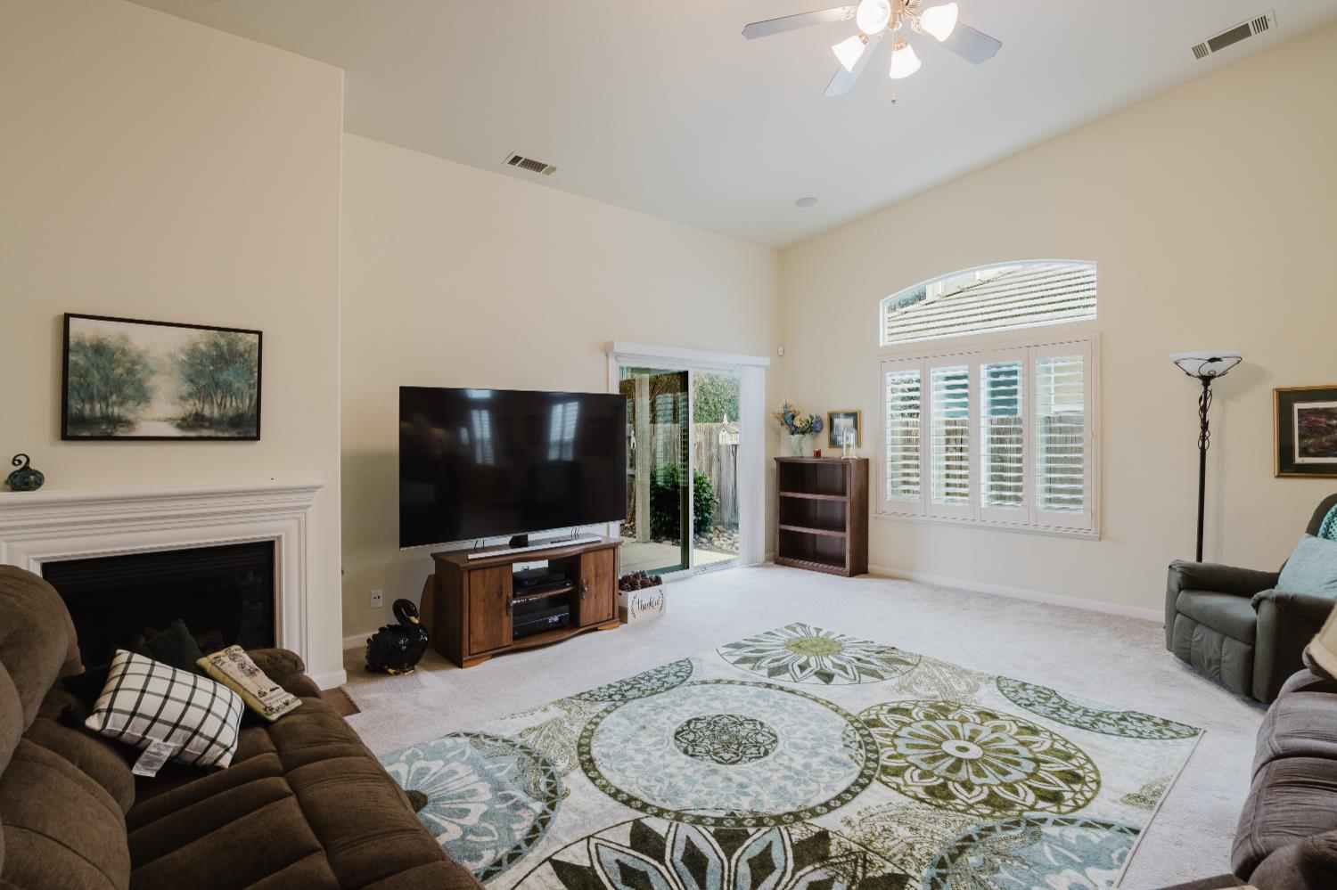 1634 Judith Way Escalon, CA 95320 - Photo 20 of 40 a living room with furniture a fireplace and a flat screen tv