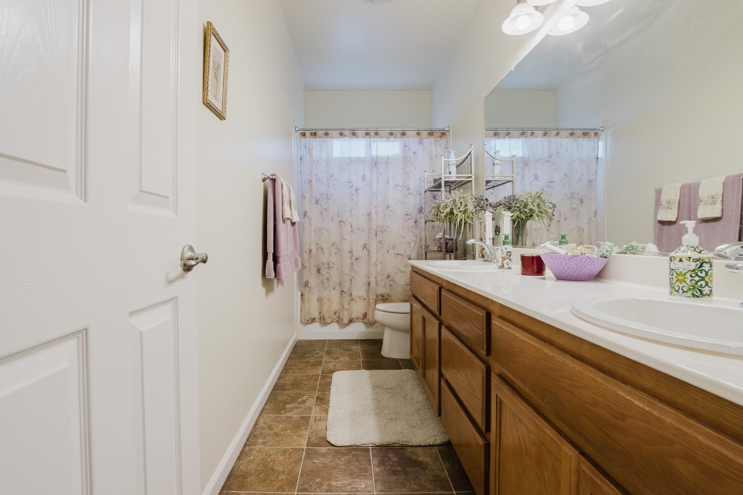 1634 Judith Way Escalon, CA 95320 - Photo 25 of 40 a bathroom with a double vanity sink a toilet and shower