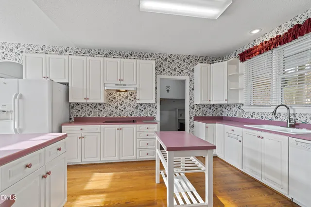 a kitchen with granite countertop a sink stove and cabinets