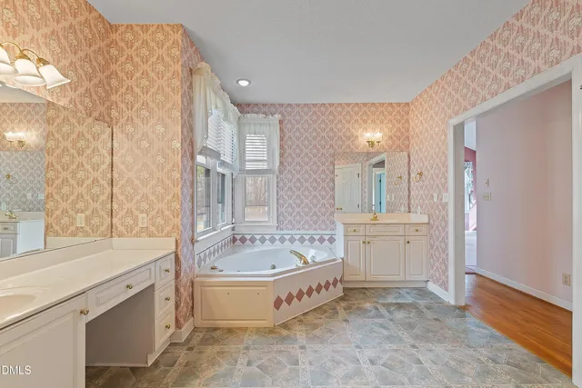 a spacious bathroom with a tub sink shower and mirror