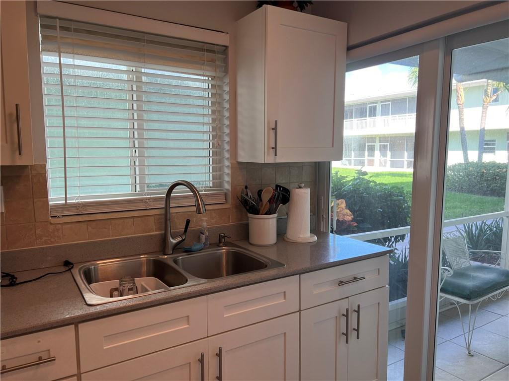 2100 Northeast 38th Street, Unit 124 Lighthouse Point, FL 33064 - Photo 2 of 30 a kitchen with a sink a counter and cabinets