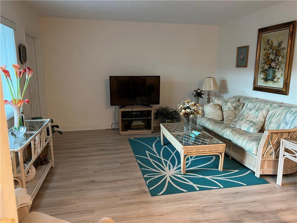 2100 Northeast 38th Street, Unit 124 Lighthouse Point, FL 33064 - Photo 5 of 30 a living room with furniture and a flat screen tv