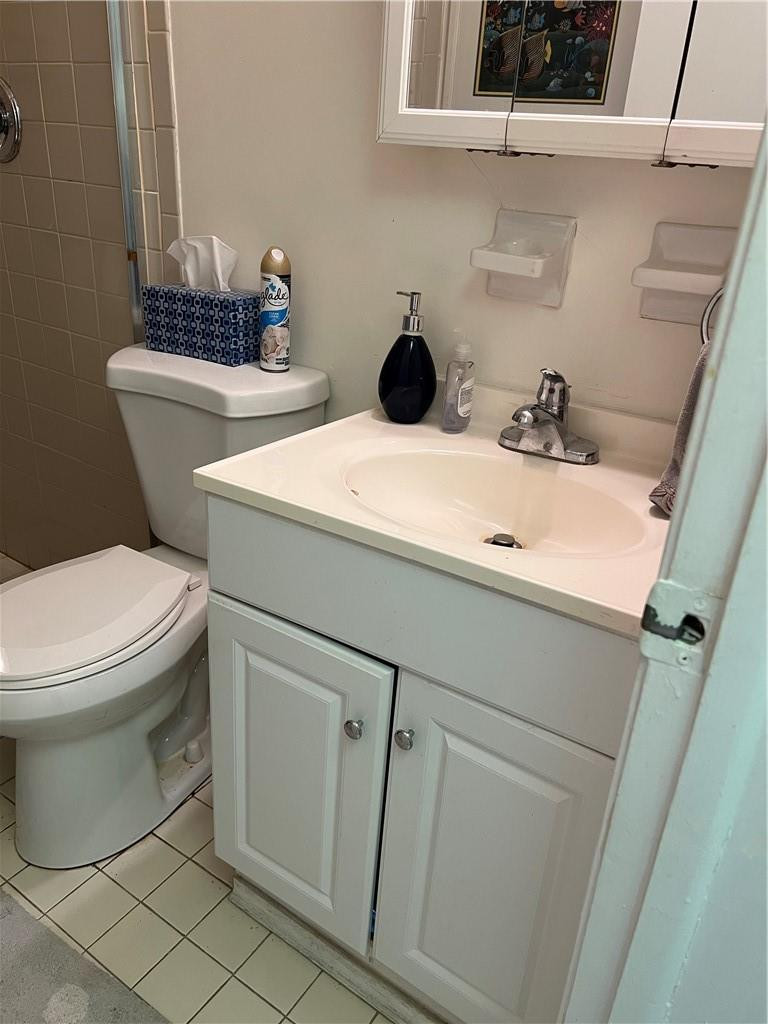 2100 Northeast 38th Street, Unit 124 Lighthouse Point, FL 33064 - Photo 8 of 30 a bathroom with a toilet sink and mirror