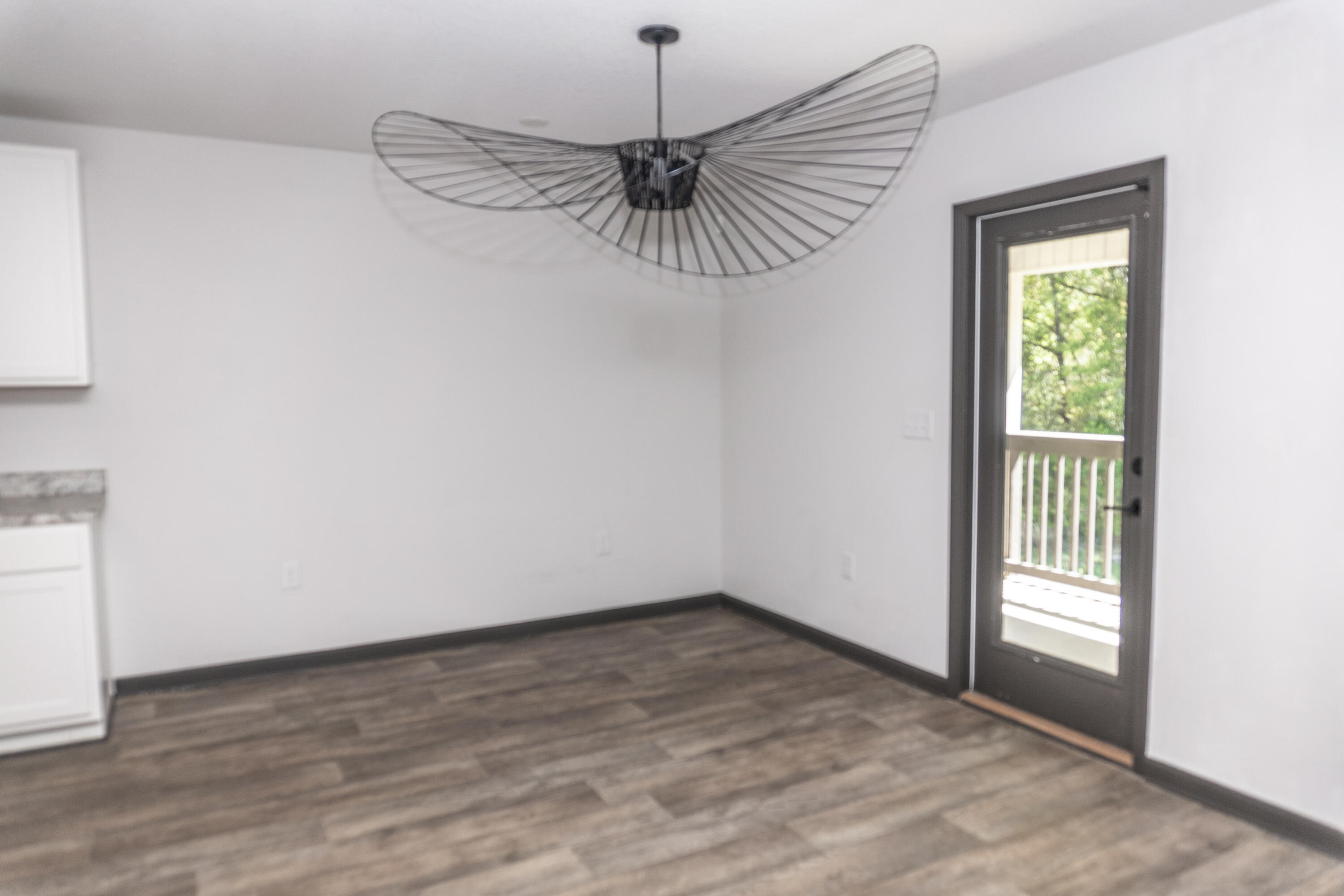 3476 Sparco Drive Crestview, FL 32539 - Photo 7 of 24 an empty room with a chandelier fan and windows