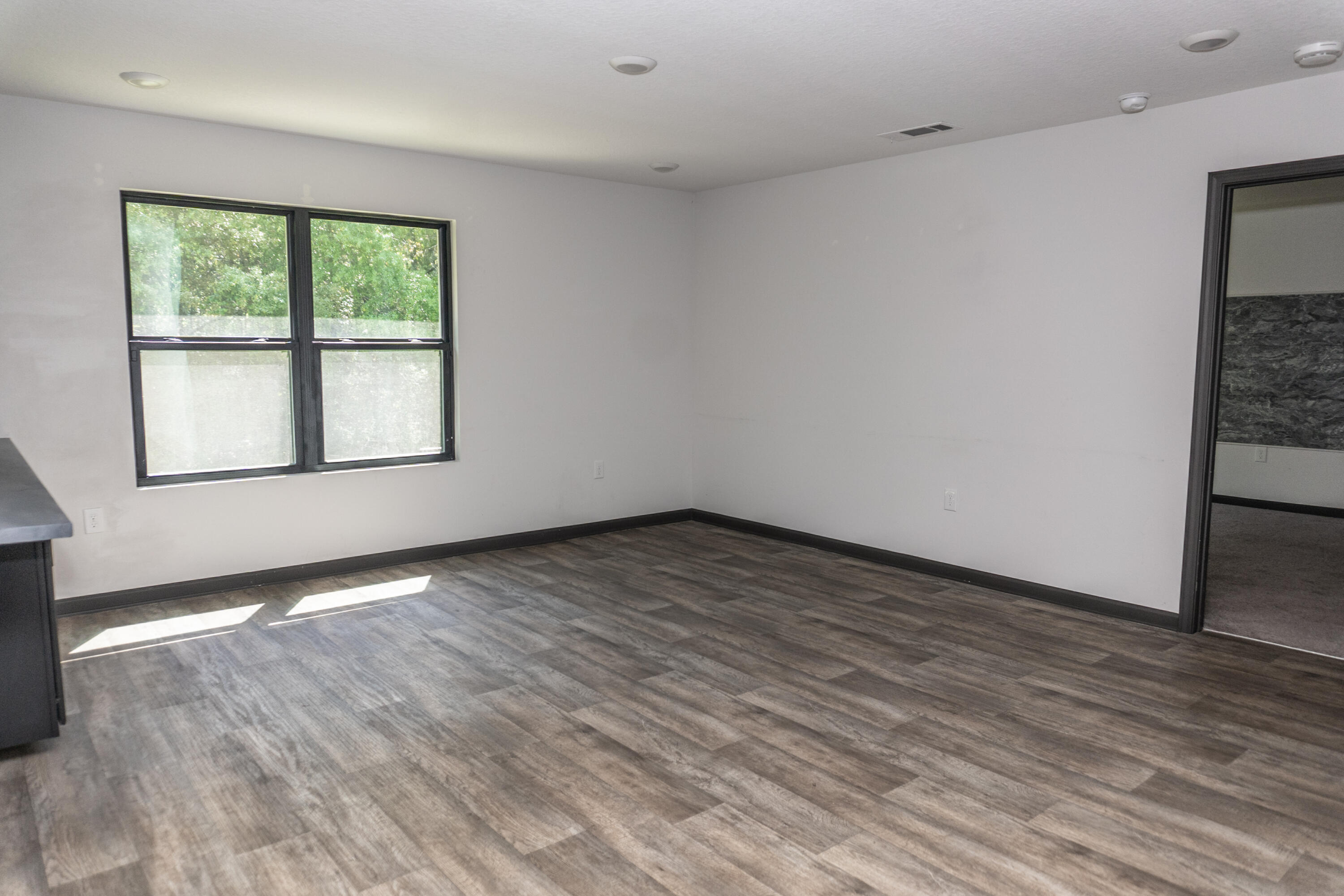 3476 Sparco Drive Crestview, FL 32539 - Photo 8 of 24 an empty room with wooden floor and windows