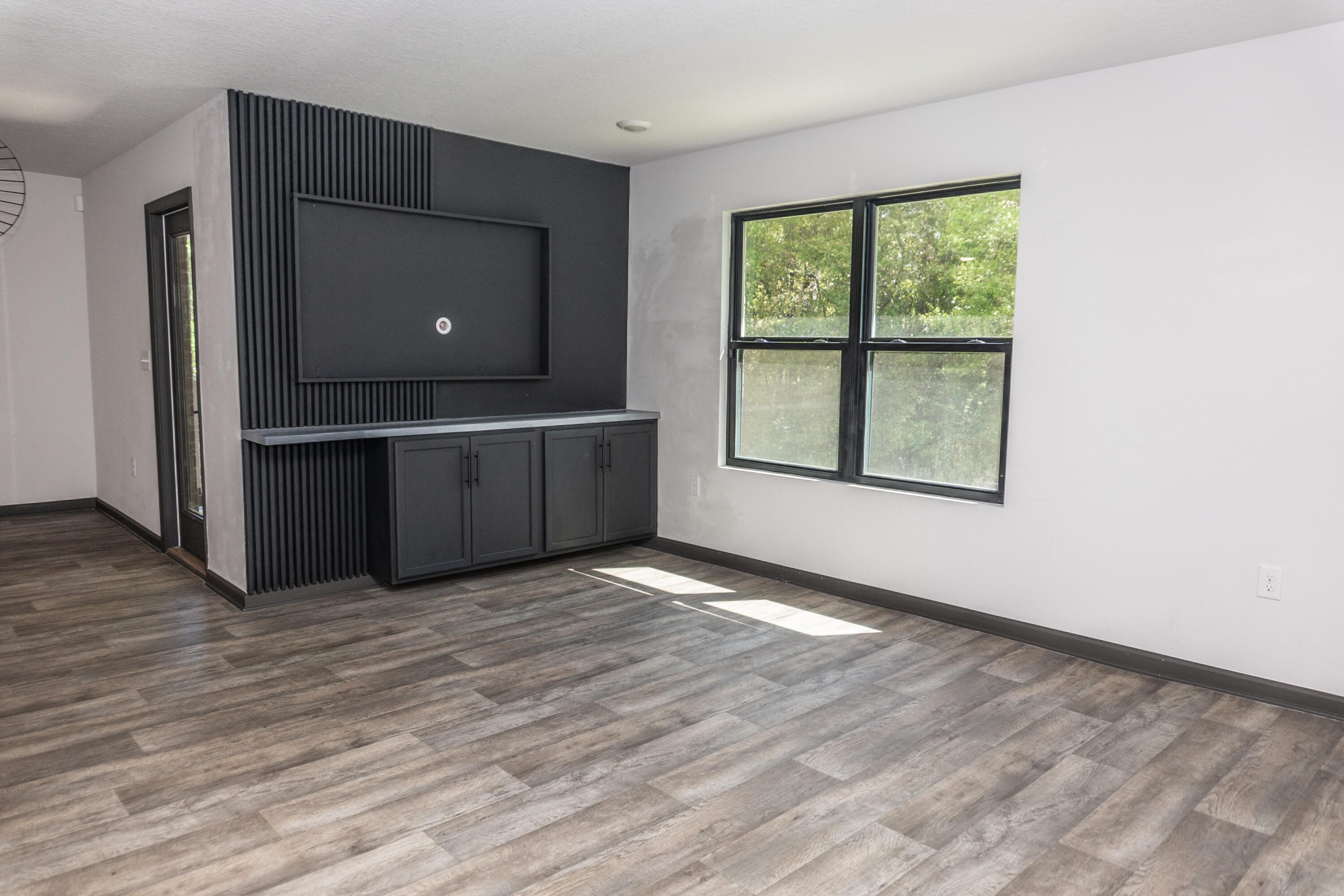 3476 Sparco Drive Crestview, FL 32539 - Photo 9 of 24 a view of an empty room with wooden floor and a window
