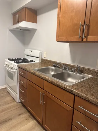 a kitchen with granite countertop a sink a stove and cabinets